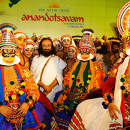 sri sri ravishankar standing amidst kathakali artists on stage